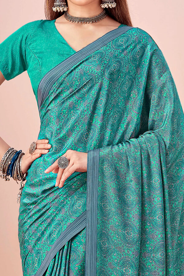 Model wearing teal crape silk saree with ethnic motifs and border – Kiran Sarees